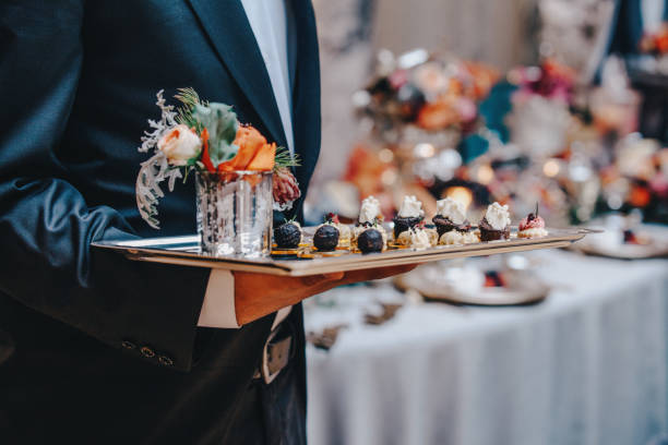 Professional caterer with white glove serve finger dessert foods during a cocktail wedding parties or events catering.